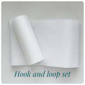 May include: A white hook and loop fastener set. The set includes a roll of hook and a roll of loop.