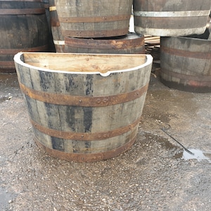 May include: Half barrel planter made of wood with metal bands. The planter is weathered and has a rustic look.