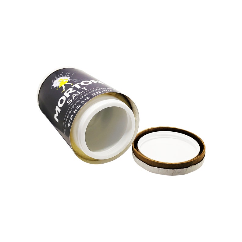 May include: A black and white Morton Salt container with a yellow bird logo. The container is open and the lid is off. The container is made of cardboard and has a white plastic liner.