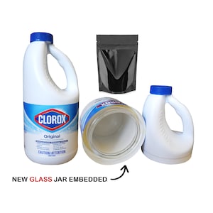 May include: A white plastic bottle with a blue lid and a Clorox label. The bottle is labeled "Original" and has a warning label that reads "Caution/Attention Irritant". The bottle is empty and has a glass jar embedded inside. The glass jar is visible through the plastic bottle. The bottle is sitting on a white surface.