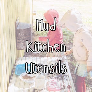 May include: A child's outdoor mud kitchen setup with the words "Mud Kitchen Utensils" in white. The scene includes a metal container, a blue container, a white bowl, a mug, and a pink toy stove on a white table.
