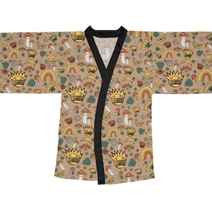 May include: A beige kimono-style robe with a repeating pattern of whimsical illustrations. The design includes mushrooms, rainbows, crowns, and eyes in shades of yellow, orange, and green. The robe has black trim along the collar and edges.