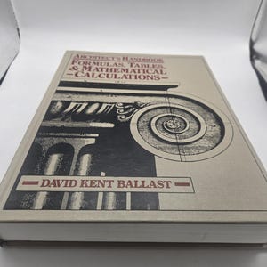 Può includere: Un libro con copertina rigida intitolato "Architect's Handbook Formulas, Tables & Mathematical Calculations" di David Kent Ballast. La copertina presenta un'illustrazione architettonica in bianco e nero su sfondo beige.
