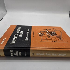 Può includere: Un libro arancione e nero intitolato "Carpenters and Builders Library" di Audel. Il libro presenta illustrazioni di utensili e macchinari. Il dorso recita "Millwork-Power Tools-Painting".