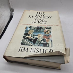 May include: A vintage hardcover book titled "The Day Kennedy Was Shot: An Uncensored Minute-by-Minute Account of November 22, 1963" by Jim Bishop.