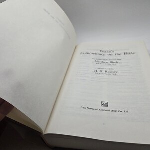 May include: A white book with the title "Peake's Commentary on the Bible" on the cover. The book is open to a page with the names Matthew Black and H. H. Rowley. The publisher, Van Nostrand Reinhold (UK) Co. Ltd., is printed on the bottom of the page.