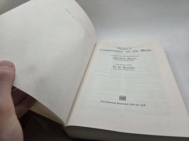 May include: A white book with the title "Peake's Commentary on the Bible" on the cover. The book is open to a page with the names Matthew Black and H. H. Rowley. The publisher, Van Nostrand Reinhold (UK) Co. Ltd., is printed on the bottom of the page.