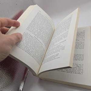 Puede incluir: Un libro abierto con p&aacute;ginas blanquecinas, sostenido por una mano. Las p&aacute;ginas est&aacute;n llenas de texto impreso. El lomo del libro es visible y las p&aacute;ginas est&aacute;n ligeramente amarillentas. El texto de la p&aacute;gina derecha incluye las palabras "Day Vol. 11".