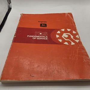 May include: An orange and red book titled "Fundamentals of Service" with the word "Engines" at the top. The book has a John Deere logo and a graphic of a wrench inside a gear.