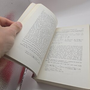 Puede incluir: Un libro abierto con texto y jerogl&iacute;ficos. Las p&aacute;ginas son de color blanquecino y el texto es negro. El libro est&aacute; abierto por una mano, revelando el contenido. El libro parece tratar sobre la historia del antiguo Egipto.