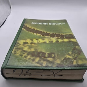 Può includere: Un libro con copertina rigida intitolato "MODERN BIOLOGY" con copertina e dorso verdi. La copertina presenta un'immagine verde e gialla. I bordi del libro sono contrassegnati da numeri scritti a mano. Il libro è in buone condizioni.