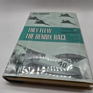 May include: A vintage book titled "They Flew the Bendix Race" by Don Wiggins. The cover features a black and white photograph of a plane with the number 40 on the side. The book is about the history of the Bendix Race, a transcontinental air race that was held annually from 1931 to 1939.