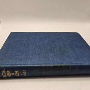 May include: A blue hardcover book titled "Structural Design in Steel" by Shedd and Wiley & Sons.