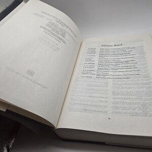 May include: A white book with a black spine. The book is open to a page with a list of names and titles under the heading "Advisory Board".