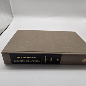 May include: A hardcover book titled "Programming Business Computers" by McCracken, Weiss, and Lee. The book has a brown cover with black and gold lettering. The publisher is Wiley.