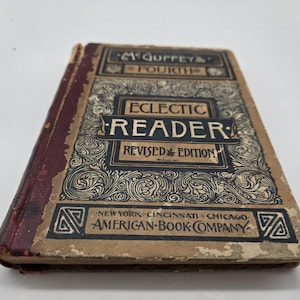 Może przedstawiać: Antyczna książka "McGuffey's Fourth Eclectic Reader, Revised Edition". Okładka jest beżowa z czarnymi i bordowymi akcentami, z ozdobnymi zawijasami i tekstem. Wydana przez American Book Company.