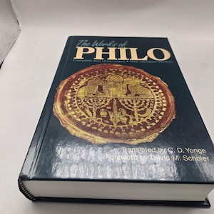 May include: A hardcover book titled "The Works of PHILO" with a dark blue cover. The cover features a gold and brown circular emblem. The book is a complete and unabridged, new updated version, translated by G. D. Yonge.