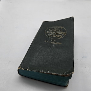 Peut inclure: Un dictionnaire Cambridge New Concise Japonais-Anglais d'occasion, de couleur vert foncé. Le livre a une couverture texturée et usée avec des lettres dorées et une tranche turquoise. Le titre est imprimé en cercle.