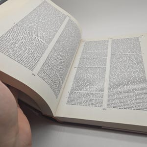 May include: An open book with white pages and black text. The book is open to a page with the heading "The Judgment of the Flood".