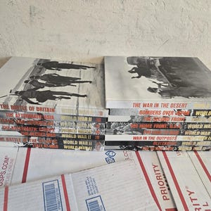 Peut inclure: Une tasse en céramique blanche avec une anse noire et le texte "But First, Coffee" en gras noir. La tasse est posée sur un fond neutre, soulignant son design simple.