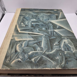 May include: A vintage book with a blue and white illustrated cover depicting a coastal scene with a lighthouse, buildings, and palm trees. The cover has a textured, almost embossed look.