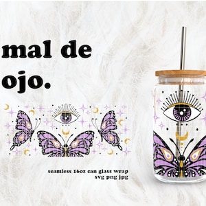 May include: A purple and gold seamless pattern with butterflies and an evil eye design. The pattern is on a clear glass tumbler with a wooden lid and a straw. The text "mal de ojo." is at the top of the image.
