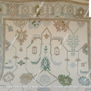 Puede incluir: Una alfombra beige con un dise&ntilde;o persa tradicional. La alfombra tiene un fondo blanco con un patr&oacute;n repetitivo de motivos florales marrones, verdes y azules. La alfombra tiene un borde con un patr&oacute;n repetitivo de formas geom&eacute;tricas marrones, verdes y azules.
