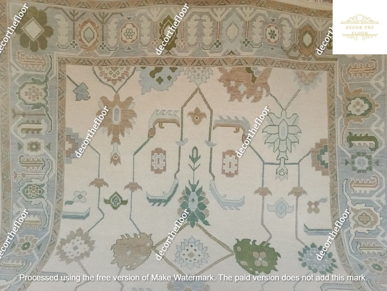 Puede incluir: Una alfombra beige con un dise&ntilde;o persa tradicional. La alfombra tiene un fondo blanco con un patr&oacute;n repetitivo de motivos florales marrones, verdes y azules. La alfombra tiene un borde con un patr&oacute;n repetitivo de formas geom&eacute;tricas marrones, verdes y azules.
