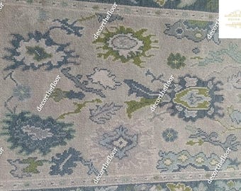 May include: A beige rug with a blue and green floral pattern. The rug has a subtle distressed look and is woven with a variety of textures.
