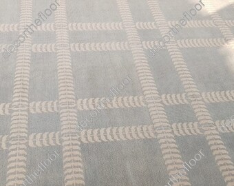 May include: A light blue carpet with a white leaf pattern. The pattern is a grid of horizontal and vertical lines.