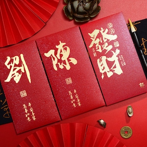 Geschenkbox mit 100 Stück angepassten chinesischen Kalligraphie-roten Umschlägen mit goldfoliertem Hong Kong Nachname Jahr der Schlange 2025