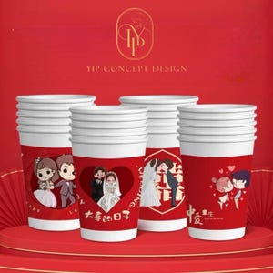 Puede incluir: Un conjunto de vasos de papel blancos con mangas rojas, adornados con ilustraciones temáticas de bodas. Los vasos muestran imágenes de parejas, corazones y el texto "YIP CONCEPT DESIGN". Están colocados sobre una plataforma roja.