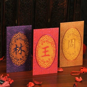5 pezzi di un set di cognomi di fascia alta di Hong Kong busta rossa porta regali personalizzati personalizzati regalo di Capodanno (蛇年剪纸镭射系列红包)