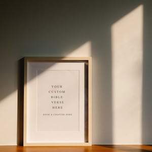 May include: A framed print with the text "YOUR CUSTOM BIBLE VERSE HERE BOOK & CHAPTER HERE" in black font on a white background.