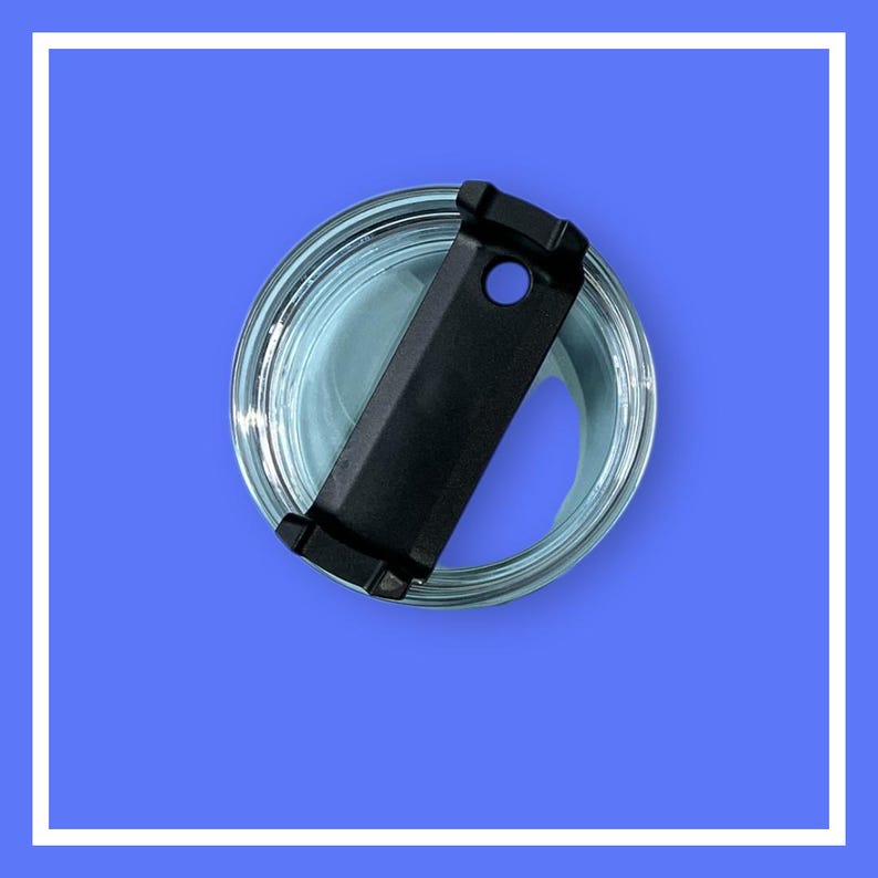 May include: A clear glass container with a black lid. The lid has a rectangular shape with a hole and two small tabs. The container is filled with a light blue liquid, and the background is a solid blue.