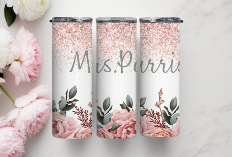 Pu&ograve; includere: Tre bicchieri in acciaio inossidabile con un design glitter oro rosa e un motivo floreale. I bicchieri hanno la scritta "Mrs. Purvis" stampata su di essi.