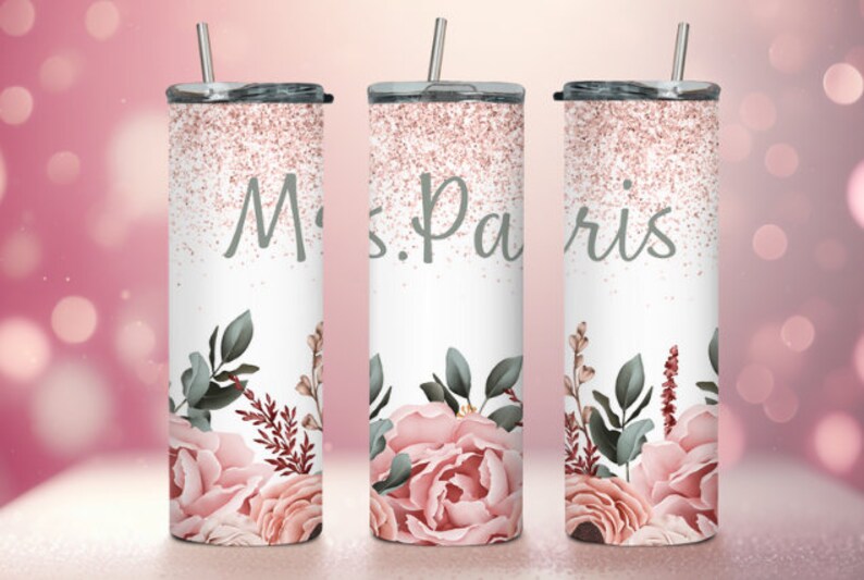 Pu&ograve; includere: Tre bicchieri in acciaio inossidabile con glitter rosa e motivi floreali. I bicchieri hanno coperchi e cannucce. Il bicchiere centrale ha il testo "Mrs. Paris".