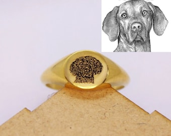 May include: A gold signet ring with a black and white engraved image of a dog's head. The ring is on a brown surface. The text "Your Pet" is visible in the background.