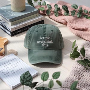 May include: A green baseball cap with white embroidery that reads "let me overthink this".