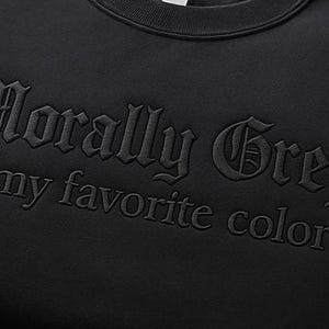 K&ouml;nnte beinhalten: Schwarzes Sweatshirt mit dem gestickten Schriftzug "Morally Grey is my favorite color" in einer gotischen Schriftart. Der Text ist farblich auf den dunklen Stoff abgestimmt.