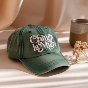 Può includere: Un cappellino da baseball verde con la scritta "Chinga la Migra" ricamata in bianco. Il cappellino ha una visiera curva e un classico design a sei pannelli. Il cappello è realizzato in un tessuto morbido e resistente.