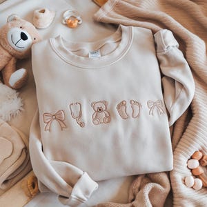 Sudadera bordada de enfermera de la UCIN, camisa con lazos coquetos para enfermeras de la UCIN, enfermera neonatal, camisa de la UCI neonatal, agradecimiento a la enfermera, regalo de camisa de enfermera.