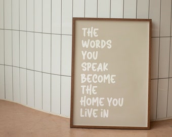 May include: A framed beige poster with the text "The words you speak become the home you live in" in white lettering.
