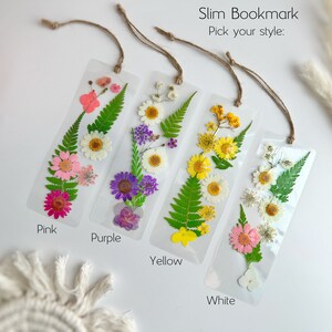May include: Four pressed flower bookmarks with a choice of pink, purple, yellow, or white flowers. Each bookmark is made with real pressed flowers and has a string attached for hanging.