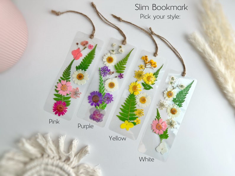 May include: Four pressed flower bookmarks with a choice of pink, purple, yellow, or white flowers. Each bookmark is made with real pressed flowers and has a string attached for hanging.