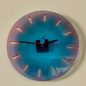 Clear epoxy resin and pigment clock. The clock mechanism can be seen through the clock. Numbers are simply open areas. Minimalist clock.