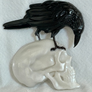 Quoth the raven, “Nevermore.” Raven standing on a skull. Halloween decor, wall hanging