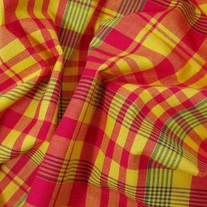 Peut inclure: Un tissu présentant un motif à carreaux vibrant avec des lignes entrecroisées en jaune vif, rouge profond et de fines rayures vert foncé. Le matériau est rassemblé en plis souples, créant une surface texturée qui souligne le tissage coloré.