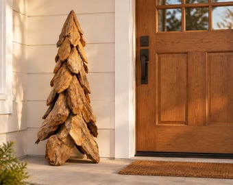 Puede incluir: Una escultura decorativa con forma de árbol cónico, construida a partir de numerosas piezas superpuestas de madera flotante natural de color marrón claro. La escultura presenta un aspecto texturizado y estratificado.