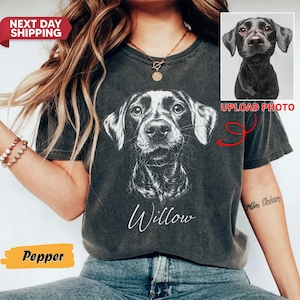 May include: Dark gray t-shirt featuring a black and white dog portrait with the name "Willow" in script. The shirt includes a small image of a dog and the words "Upload Photo". The word "Pepper" is displayed in a yellow box.